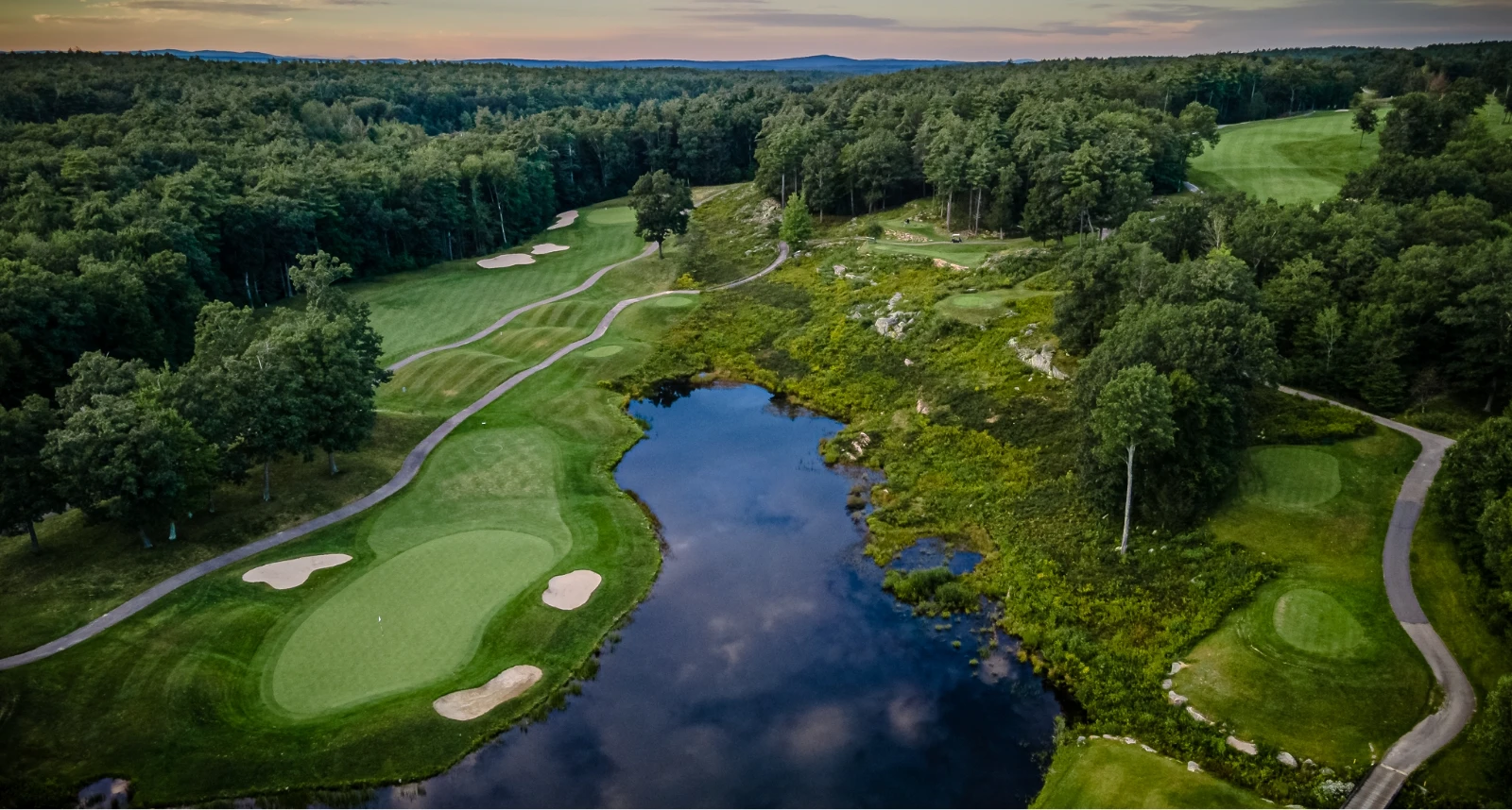 Ledges Golf course hole overview green grass bright blue water