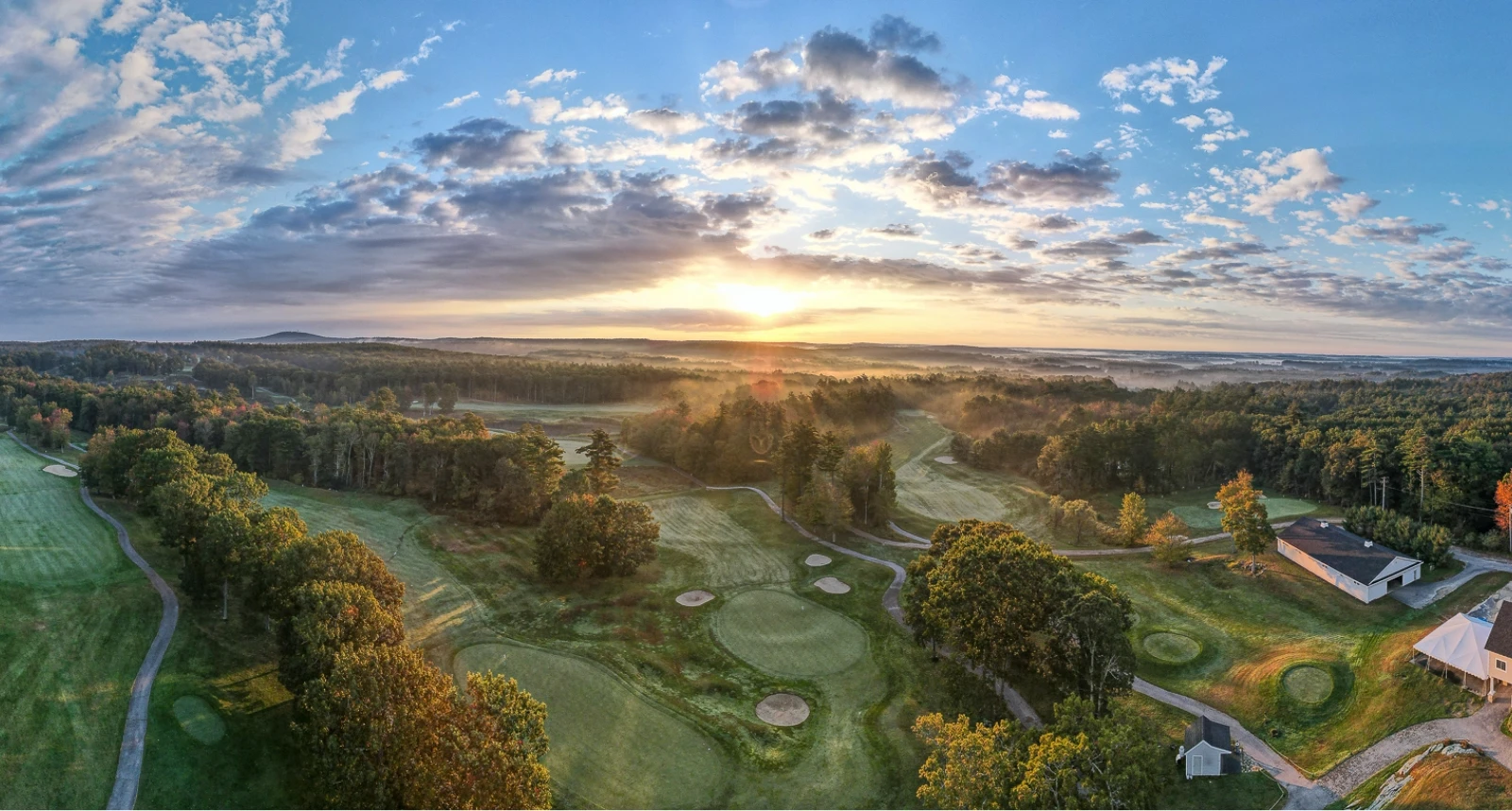 Ledges Golf course hole overview green grass and mist with beautiful clouds in sky